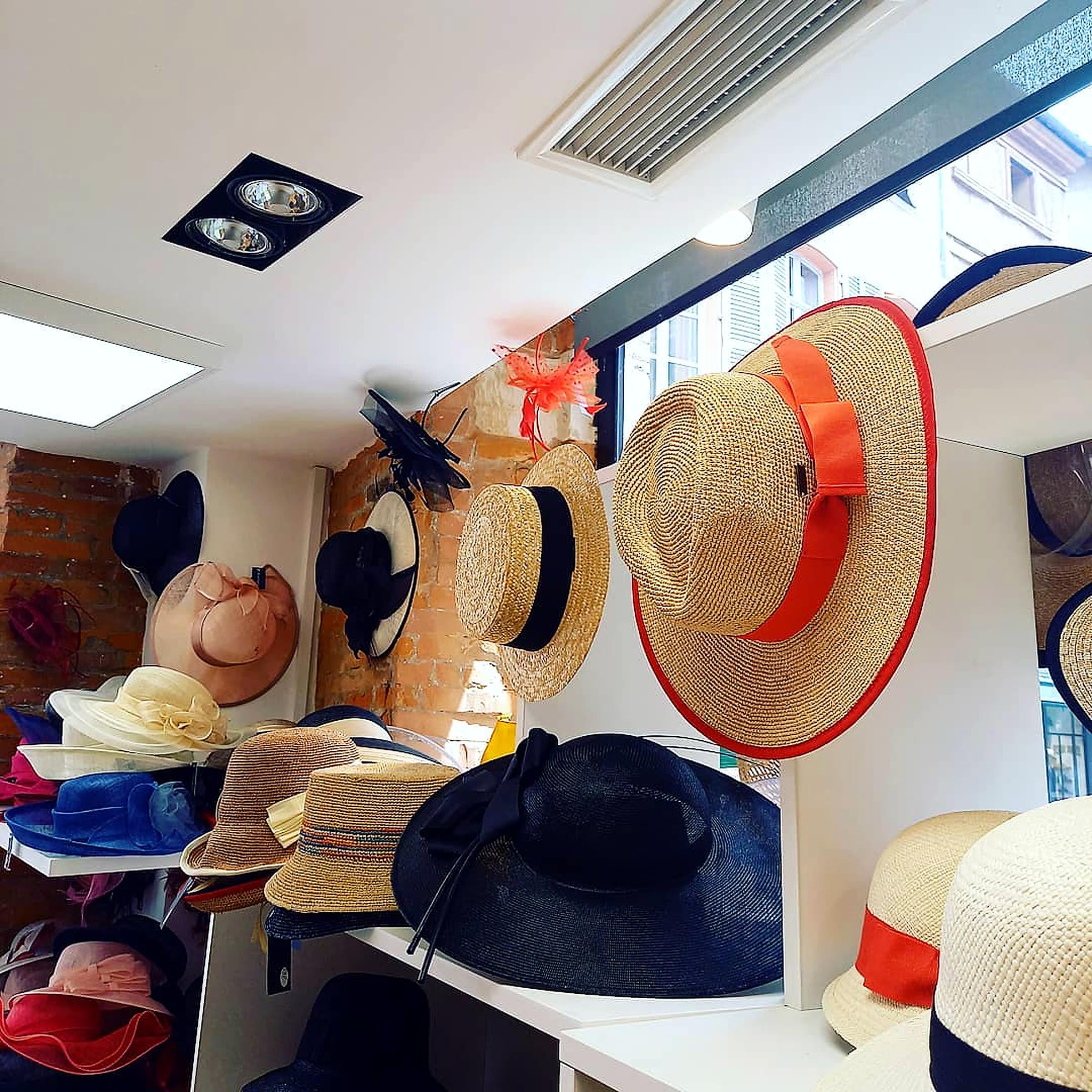 Interior de una boutique de sombreros: pamelas, canotiers y sombreros de ceremonia