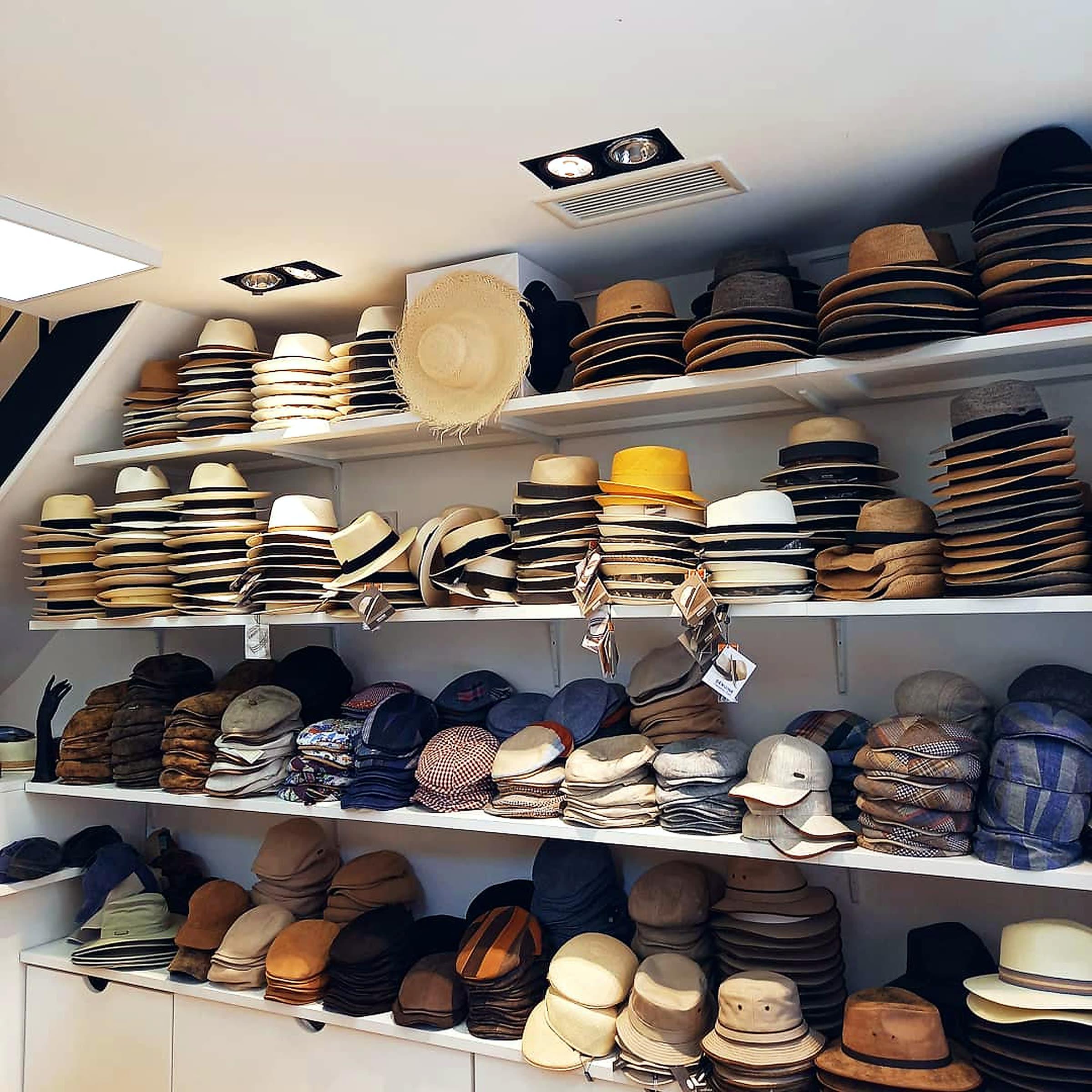 Estanterías de una boutique llenas de panamás, canotiers y gorras